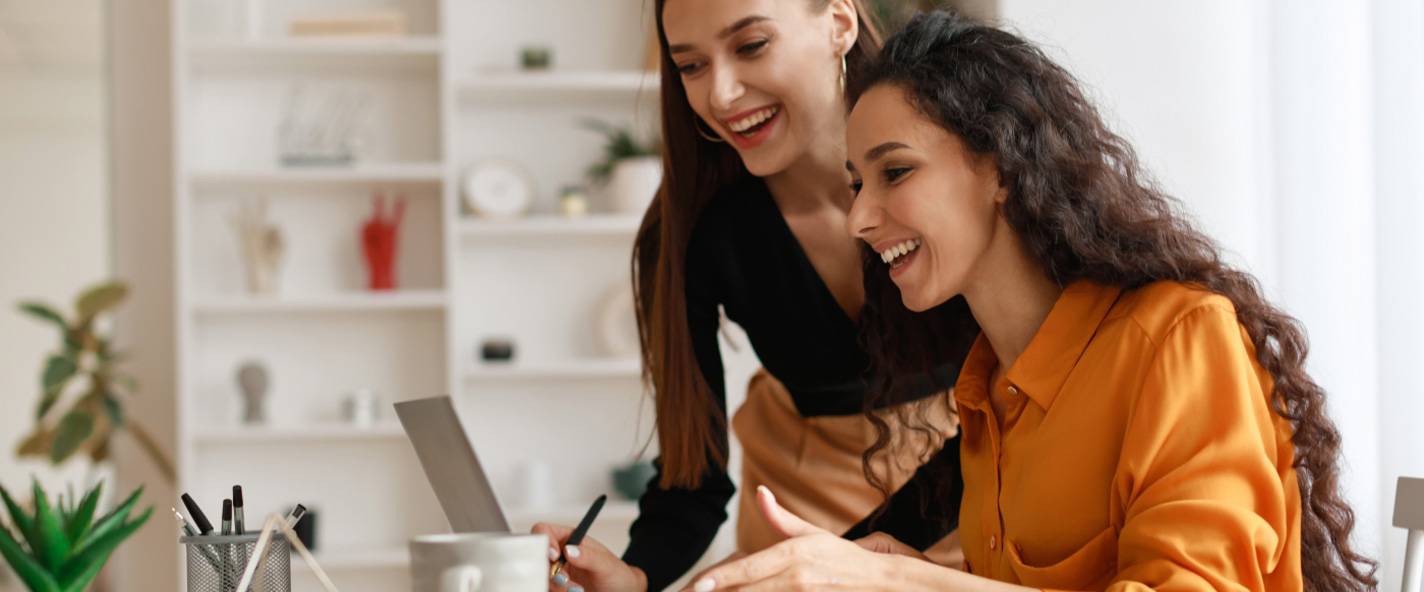 cover-pilar-two-happy-ladies-using-laptop-computer-working-onl